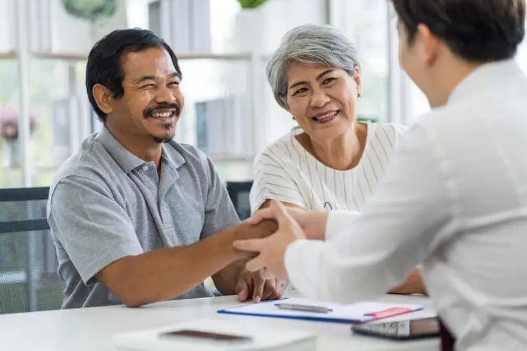 Middle-aged couple shakes hands with a Phoenix financial consultant